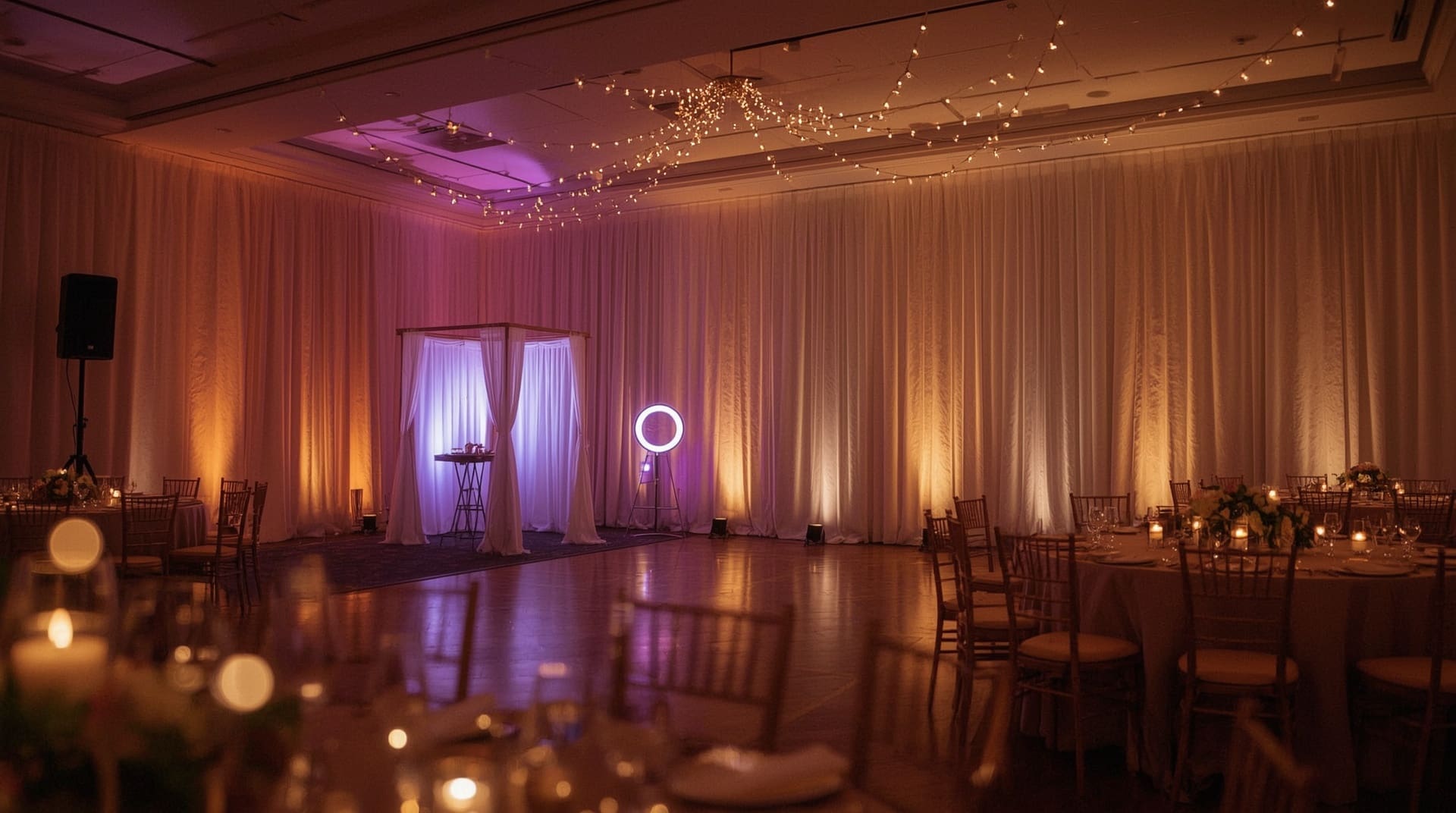 Elegant wedding reception ballroom with uplighting photo booth and speaker setup